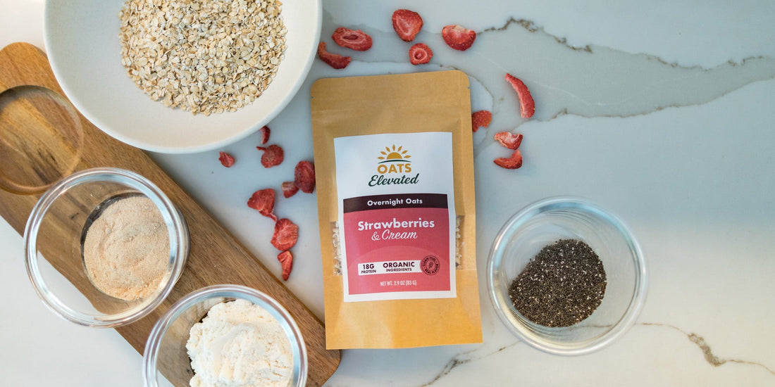 An Oats Elevated Strawberries and Cream pouch surrounded by its raw ingredients: rolled oats, date sugar, whey protein isolate, chia seeds and freeze-dried strawberries