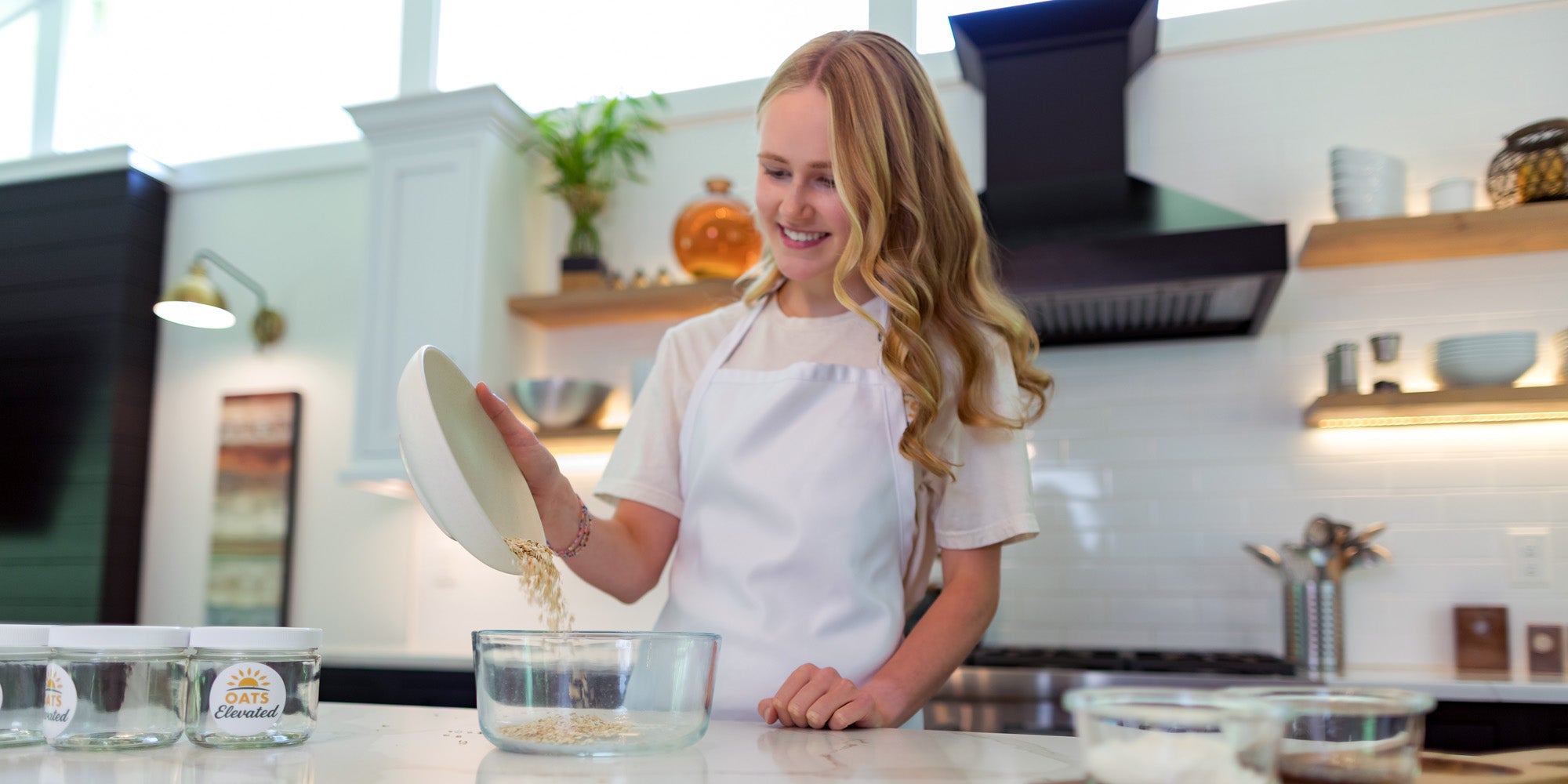 Brooke Sweeney, founder of Oats Elevated, preparing a fresh batch of overnight oats in her kitchen.