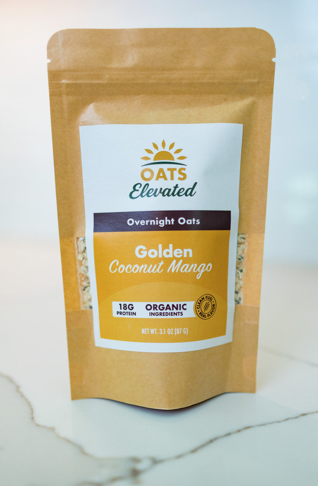 Front of package of Oats Elevated Golden Coconut Mango Overnight Oats with organic ingredients, high-protein breakfast.
